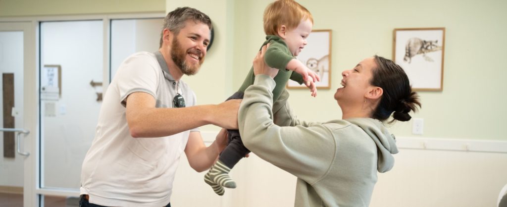father dropping off baby with daycare provider